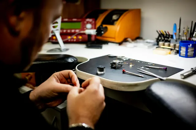 Technicien horloger professionnel de timeondines travaillant à son établi avec des outils de précision